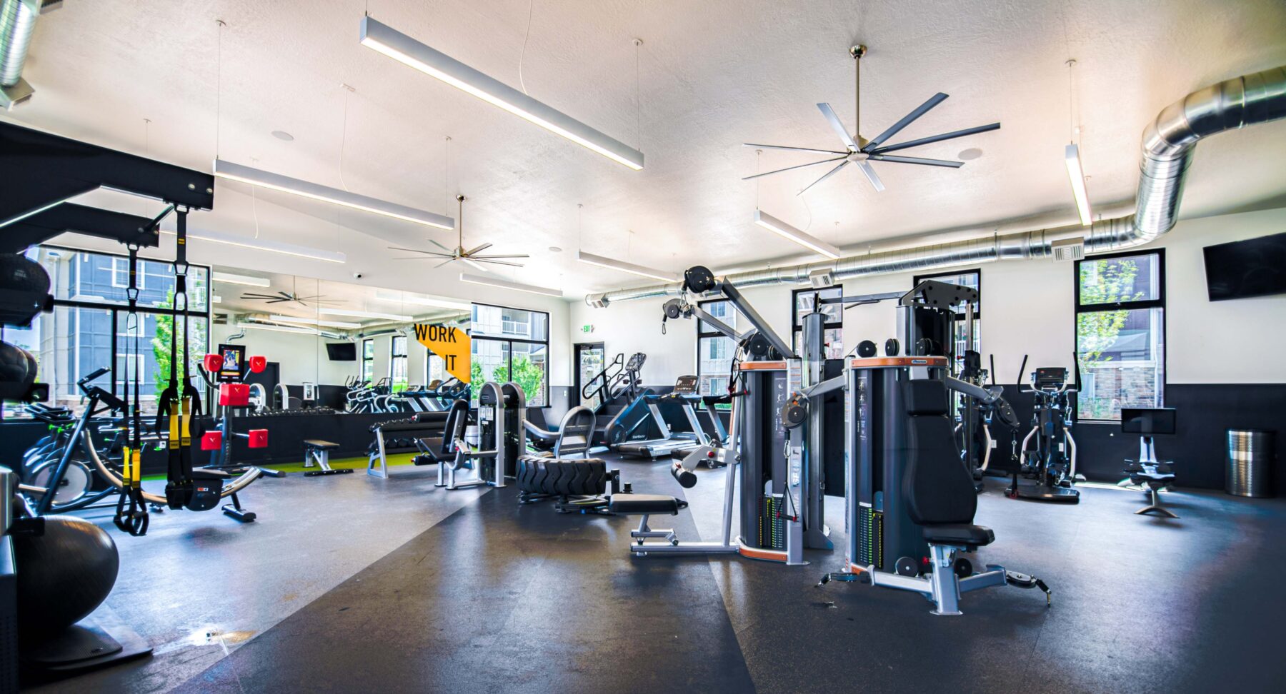 indoor gym with exercise equipment and ceiling fans