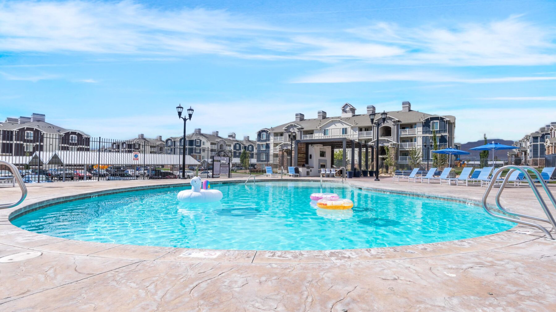 Pool with deck seating and pavilion at Copperwood apartments near The District in South Jordan, UT
